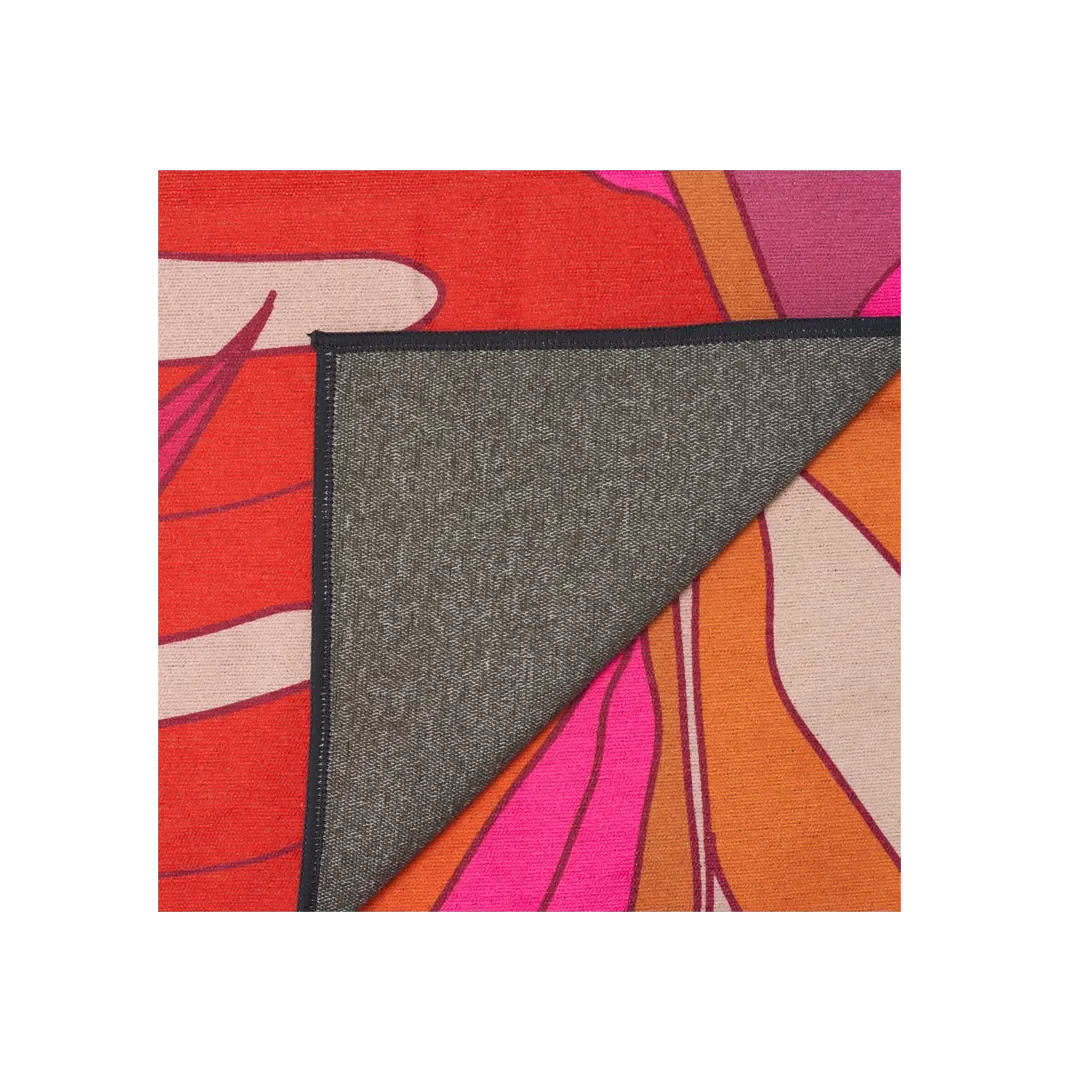 Owala towel in Tropic Like It's Hot, back detail showing the corner folded over to reveal grey microfiber backing against a pink, red, and orange print