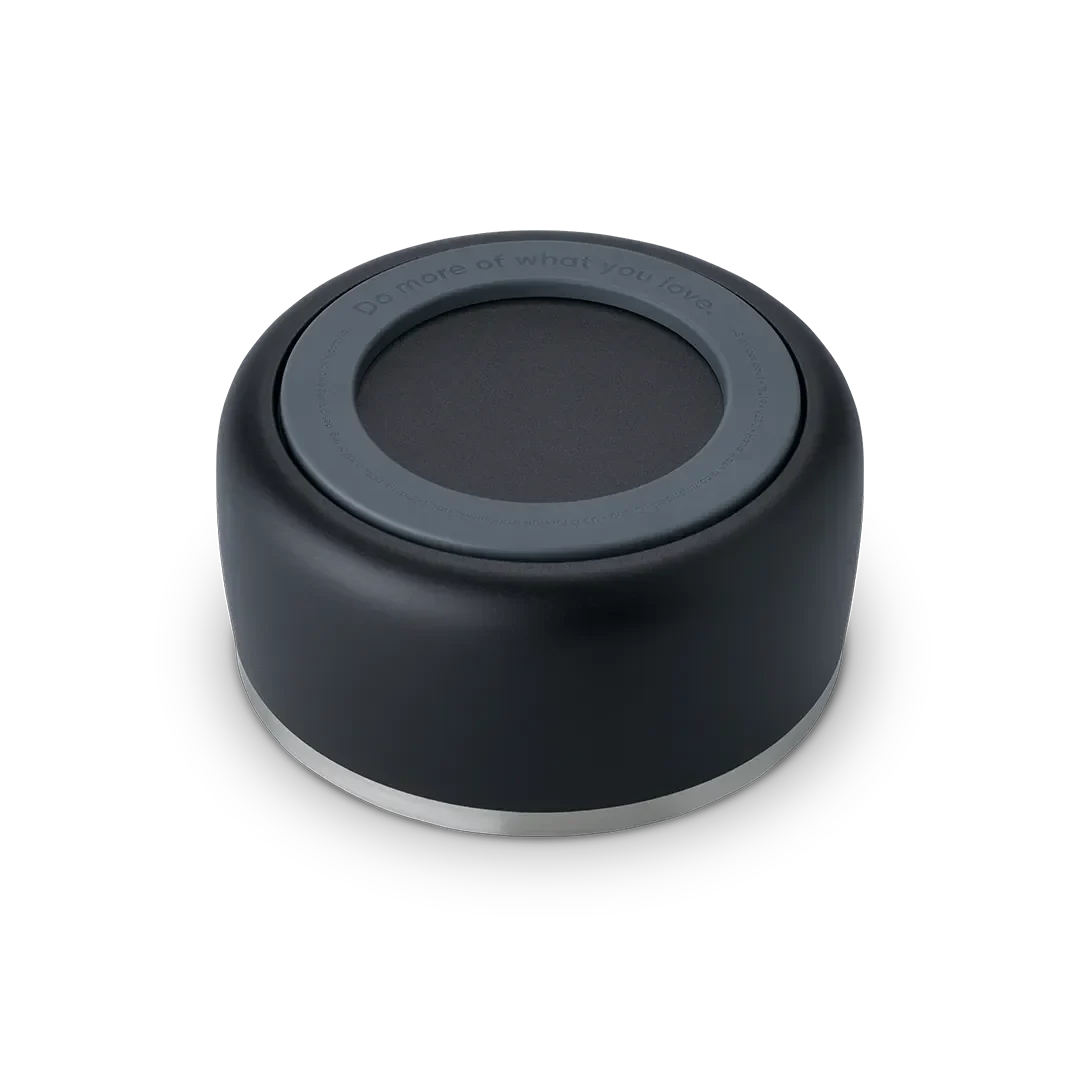 Owala Pet Bowl, bottom view showing black silicone cup exterior with dark gray accent ring embossed with "Do more of what you love" and thin stainless steel band at rim